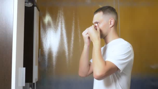 Retrato de um homem bonito com uma máscara sob as pálpebras, no banheiro. Conceito metrosexual, cuidados com o rosto — Vídeo de Stock