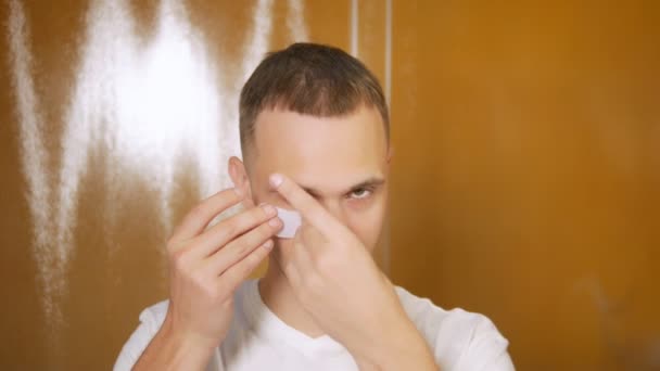 Porträt eines gutaussehenden Mannes mit Maske unter den Augenlidern, im Badezimmer. metrosexuelles Konzept, Gesichtspflege — Stockvideo
