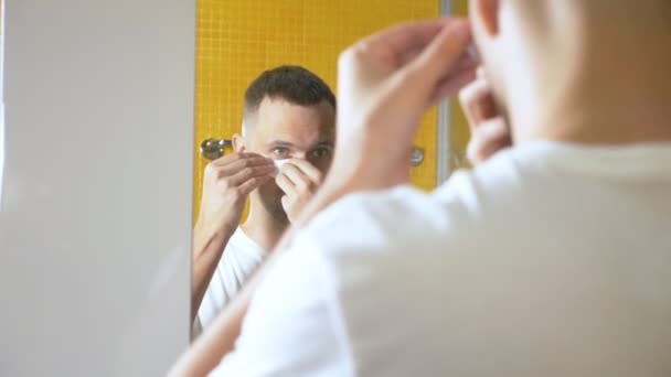 Portré egy jóképű férfi egy maszk alatt a szemhéj, a fürdőszobában. Metrosexual koncepció, Arcápolás — Stock videók