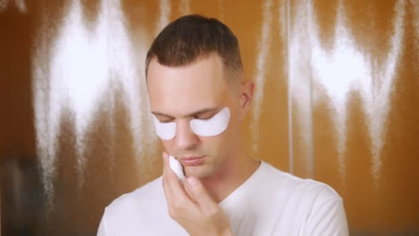 Portrait d'un bel homme avec un masque sous la paupière inférieure, qui est rasé avec un rasoir droit dans la salle de bain. Concept métrosexuel — Video