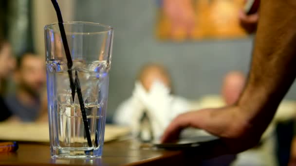 Friendly party concept. close-up of a glass with a cocktail on the background of blurry people — Stock Video