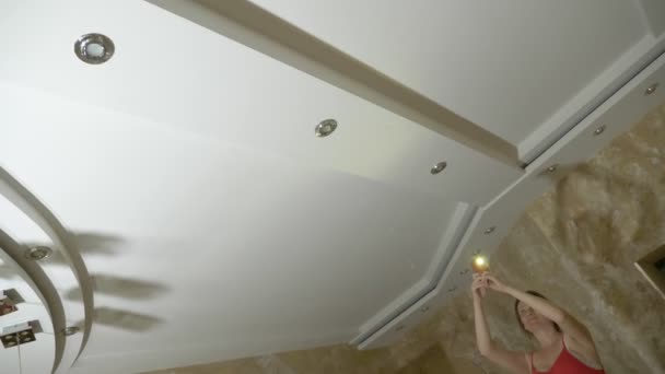 Vatten skador. konceptet att översvämma lägenheten och egendoms försäkringen. en kvinna tar ett foto på telefonen som vatten droppar från taket i hennes lägenhet — Stockvideo