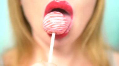 yakın çekim, kırmızı ruj ile kadın seksi dudaklar büyük pembe yuvarlak Lollipop emmek. alanı kopyalayın. mavi arka plan