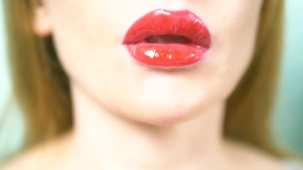 Close-up. sexy lippen van een mooie vrouw met mooie rode make-up, likt haar lippen — Stockvideo