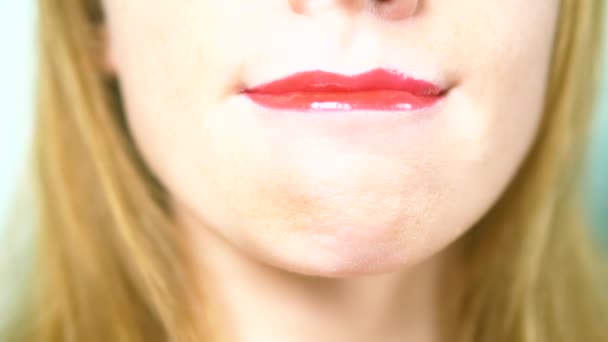 Close-up. sexy lippen van een mooie vrouw met mooie rode make-up, likt haar lippen — Stockvideo