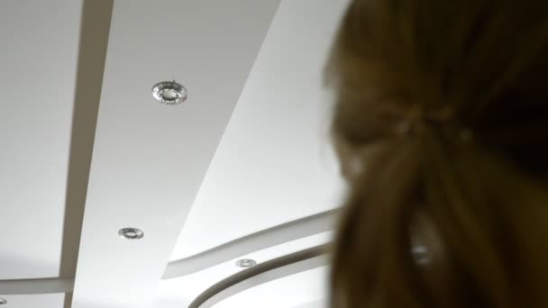 Water damage. concept of flooding the apartment and property insurance. a woman takes a photo on the phone as water drips from the ceiling of her apartment — Stock Video