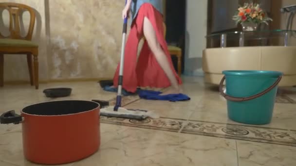 Water damage. Concept of flooding the apartment and property insurance. water drips from the ceiling in the apartment, and a woman wipes water from the floor with rags and a mop — Stock Video