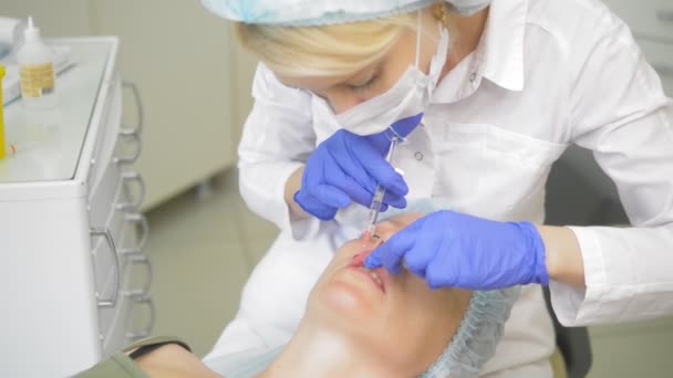 Injeção labial, operação para aumentar o volume dos lábios. médico cosmetologista faz contorno de plástico para aumentar os lábios — Vídeo de Stock