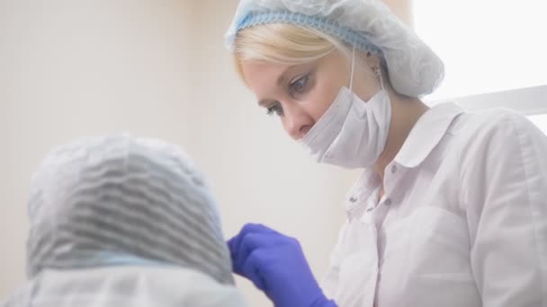 Contour plastic. Een schoonheidsspecialist injecteert een botulinum toxine aan te scherpen en glad uit rimpels op de huid van een vrouwelijk gezicht. — Stockvideo