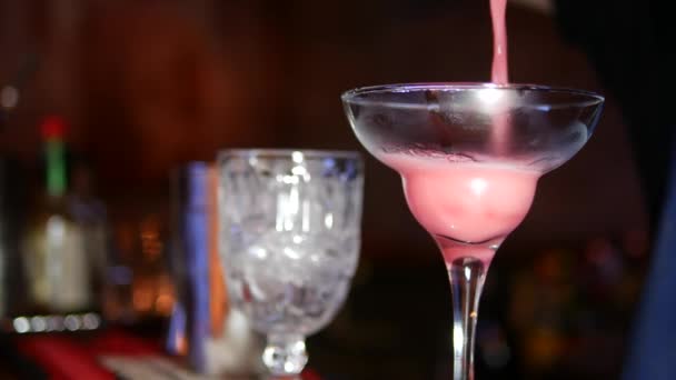 Zu schließen. Martini-Glas in Schärfe auf dem Rücken verschwommen Hintergrund Barmann macht Cocktail — Stockvideo