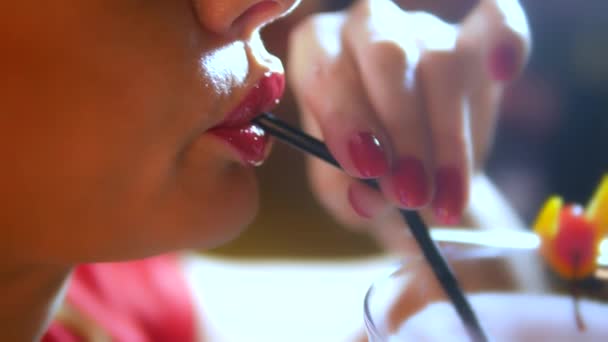 Sexy woman with red lipstick on her lips is drinking a cocktail from a glass of margarita. lips close-up — Stock Video