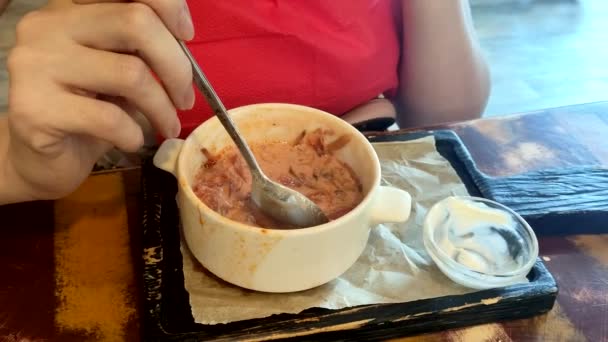 Una mujer almorzando en un café. borsch rojo con remolacha, vista superior — Vídeo de stock