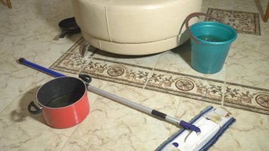 Su hasarı. Daire ve mülkiyet sigortası sel kavramı. dairede kova ve pot içine tavana su damlar