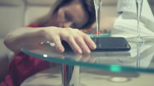 Une femme en pleurs attend quelqu'un à la maison à une table fixée pour un rendez-vous romantique pour deux. vérifie le téléphone — Photo