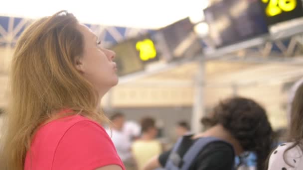 Concept de tourisme, vacances et échange de formation. Une femme et deux adolescents, un garçon et une fille, se tiennent à l'aéroport à la billetterie pour l'enregistrement des vols . — Video