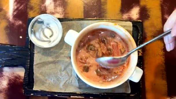 Vrouw die lunch in een café eet. rood Borsch met rode biet, bovenaanzicht — Stockvideo