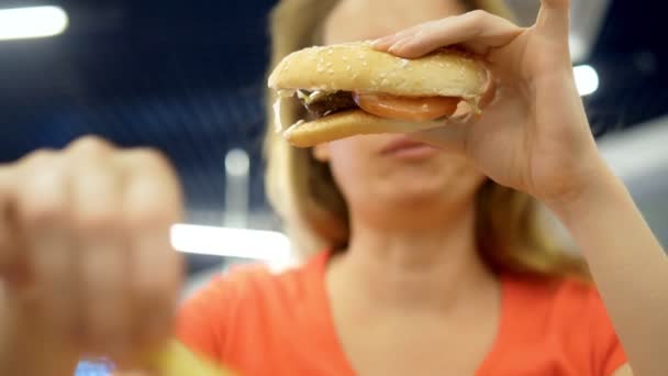 Zu schließen. Frau mit Herpes auf der Lippe isst Pommes und Hamburger — Stockvideo