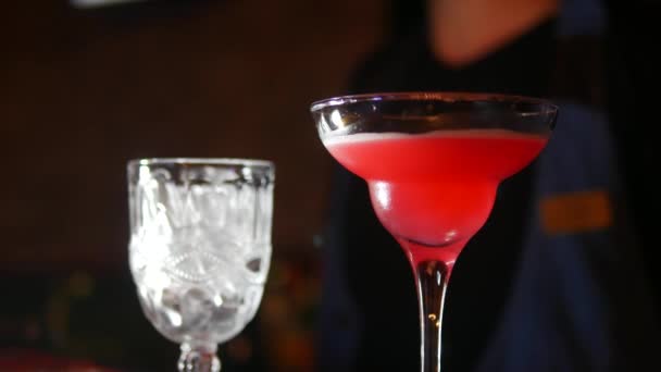 För att stänga. martini glas i skärpa på bak sidan suddig bakgrund bartender göra cocktail — Stockvideo