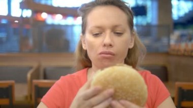 kapatmak için. dudağına uçuk olan kadın patates kızartması ve hamburger yiyor