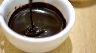 Close. Sıvı bir kaşıktan fincan içine çikolata damlama. bir kafede sıcak çikolata