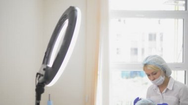 kontur plastik. Bir Kozmetolog sıkın ve bir kadın yüzü cilt kırışıklıkları pürüzsüz bir botulinum toksin enjekte.