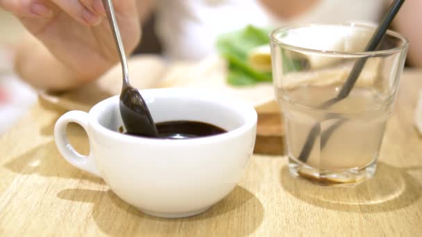 特写。液体将巧克力从勺子滴入杯子中。咖啡馆里的热巧克力 — 图库视频影像