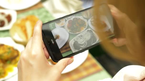 As mãos femininas fazem fotos em um smartphone em um restaurante com pratos da cozinha caucasiana. legumes grelhados, shashlik, molho — Vídeo de Stock