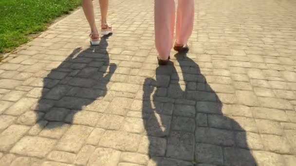 Feet close up, pedestrians walk down the street. Girls legs in pink leather sandals on a white high platform. Summer street fashion concept. Legs and shoes — Stock Video