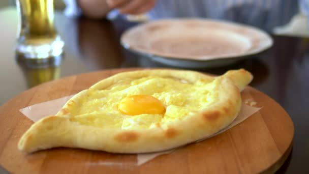 Comida nacional georgiana, Adjarian khachapuri com ovo em um prato em um restaurante — Vídeo de Stock