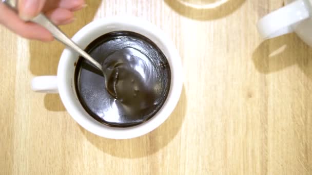 クローズ アップ。スプーンからチョコレートをカップに滴る液体。カフェでホットチョコレート — ストック動画
