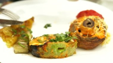 Bir restoranda ızgara sebze yakın çekim. Kadın bir bıçak ve çatal ızgara sebze ve şiş kebap ile yiyor