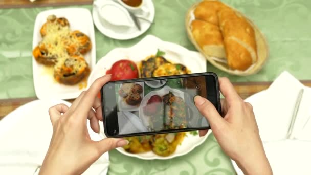 Kadın elleri Kafkas mutfağından yemekler içeren bir restoranda akıllı telefonda fotoğraf çeksin. ızgara sebze, shashlik, sos — Stok video