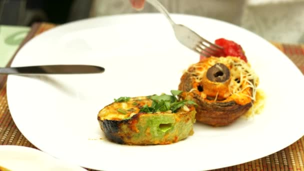 Grilled vegetables closeup in a restaurant. Woman eats with a knife and fork grilled vegetables and shish kebab — Stock Video