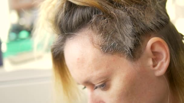 Het concept van professionele haarkleuring. een vrouw bij de kapper kleurstoffen haar haar — Stockvideo