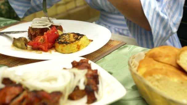 Verduras a la parrilla primer plano en un restaurante. Mujer come con un cuchillo y tenedor verduras a la parrilla y shish kebab — Vídeo de stock