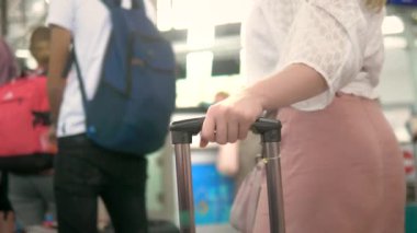 turizm ve seyahat kavramı. Close. Kadın elleri havaalanında sırada dururken bavul sapını tutuyor