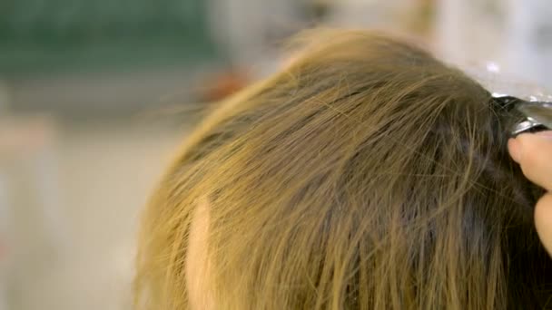 Close-up. Tingimento de cabelo no cabeleireiro. mãos de uns fios de cabelo de tintura de barbeiro e agasalho na folha metálica, cabeleireiro profissional que trabalha com o cliente no salão . — Vídeo de Stock