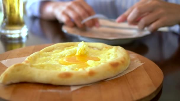 Национальная грузинская еда, Аджарии хачапури с яйцом на тарелке в ресторане — стоковое видео