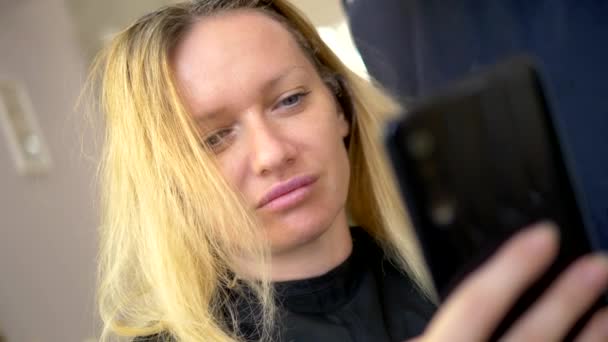 El concepto de coloración profesional del cabello. una mujer en la peluquería se tiñe el pelo — Vídeo de stock