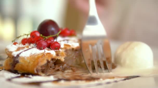 Close-up. strudel de maçã com sorvete de baunilha. As mãos cortam um pedaço de bolo com um garfo e uma faca — Vídeo de Stock