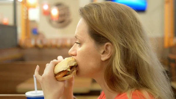 Para cerrar. mujer con herpes en el labio come papas fritas y hamburguesa — Foto de Stock
