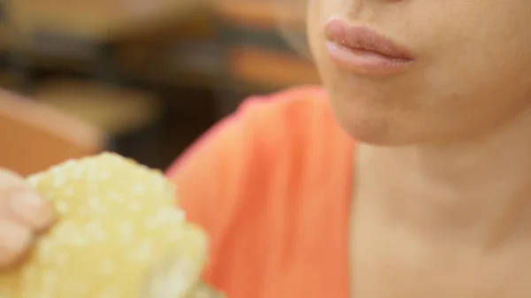 Zu schließen. Frau mit Herpes auf der Lippe isst Pommes und Hamburger — Stockfoto