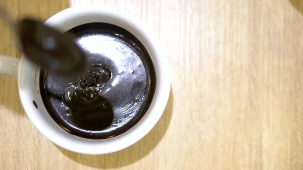 Close-up. Liquid dripping chocolate from a spoon into the cup. hot chocolate in a cafe — Stock Photo, Image