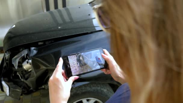 Una donna scatta una foto sul suo smartphone dopo l'incidente di un paraurti di un'auto rotta — Video Stock