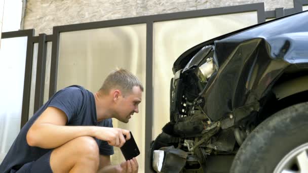 Чоловік робить фотографію на своєму смартфоні після аварії зламаного автомобіля бампера — стокове відео
