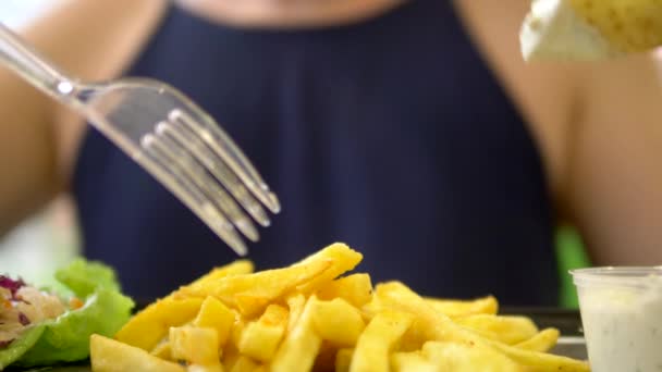 Primer plano. mujer comiendo en un restaurante de comida rápida giroscopios con ensalada de col y papas fritas — Vídeos de Stock