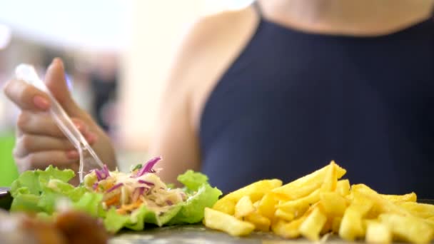 Крупным планом. женщина ест в ресторане быстрого питания гироскопы с салатом из капусты и картошкой фри — стоковое видео