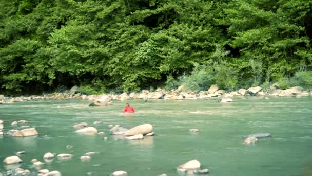 Donna esausta che affoga in un fiume di montagna. Ha preso su un masso e aspetta aiuto . — Video Stock