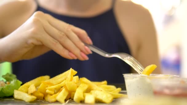 Close-up. mulher comendo em um restaurante de fast food giroscópios com salada de repolho e batatas fritas — Vídeo de Stock