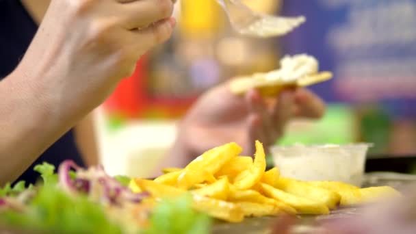 Primer plano. mujer comiendo en un restaurante de comida rápida giroscopios con ensalada de col y papas fritas — Vídeos de Stock